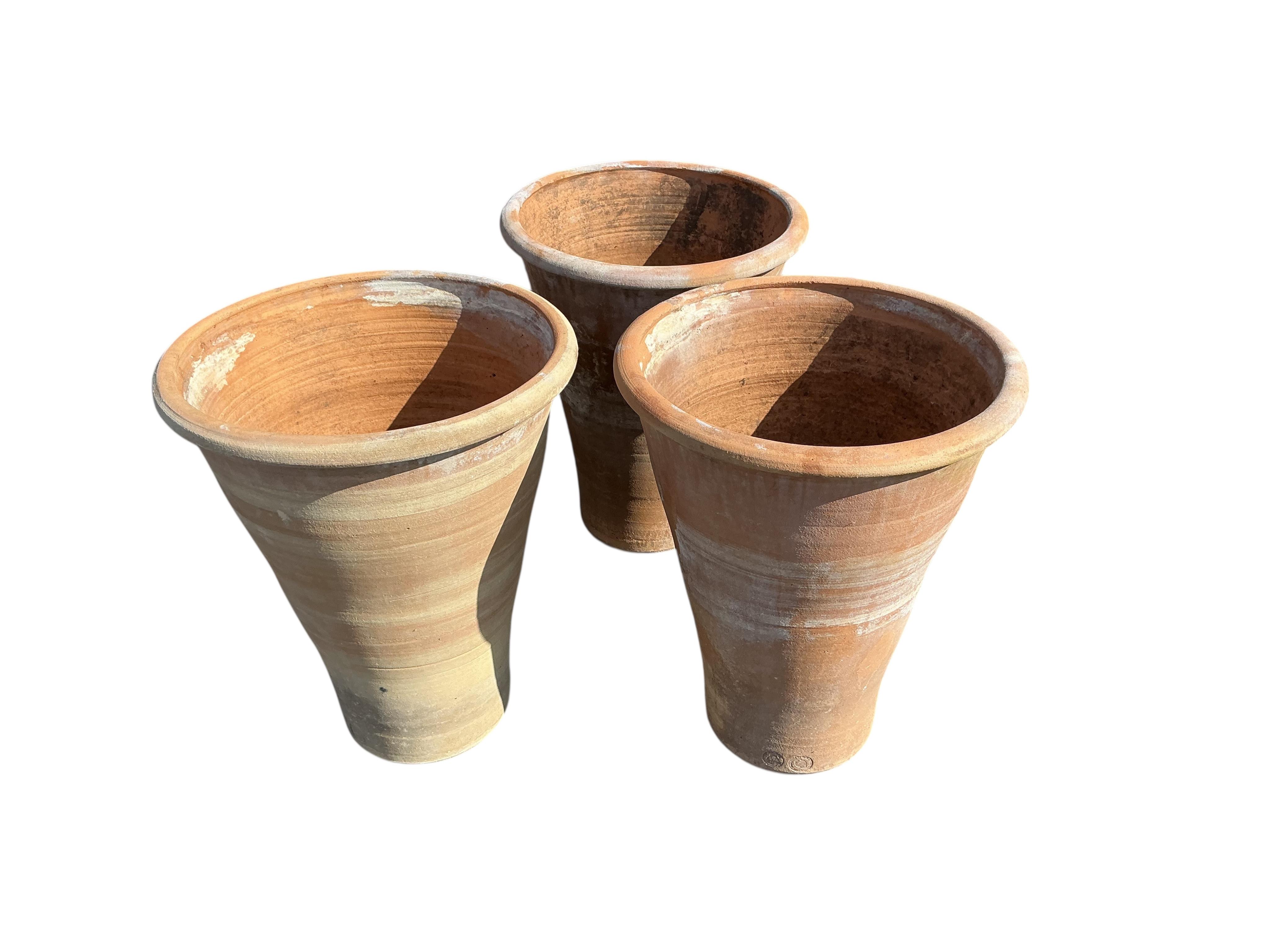 A set of three circular terracotta garden planters, diameter 50cm, height 61cm